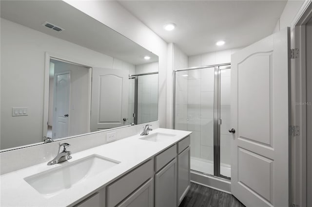 bathroom featuring hardwood / wood-style floors, vanity, and a shower with shower door