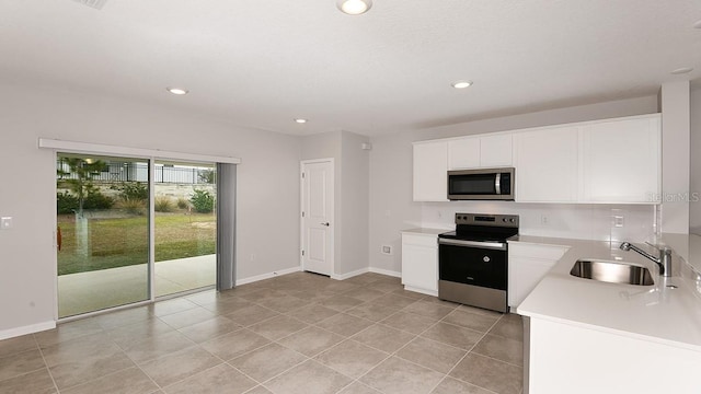 kitchen with white cabinetry, appliances with stainless steel finishes, sink, and light tile patterned floors