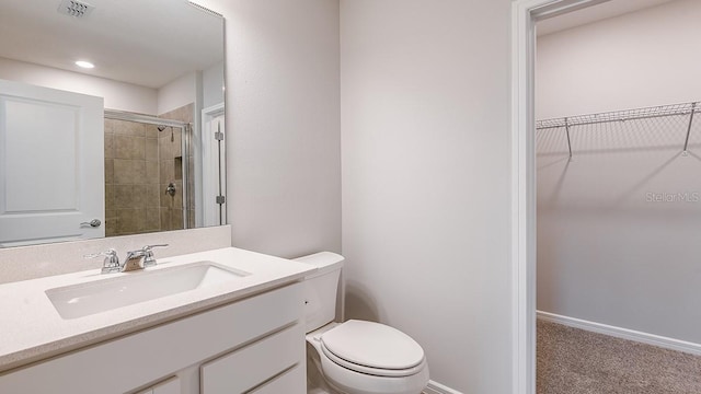 bathroom featuring vanity, a shower with shower door, and toilet