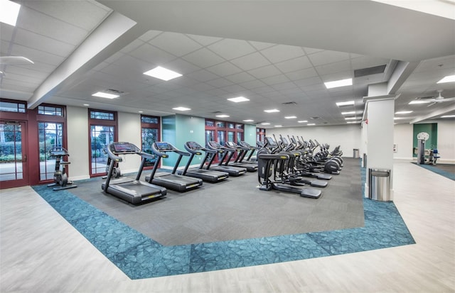 workout area with a paneled ceiling and wood-type flooring