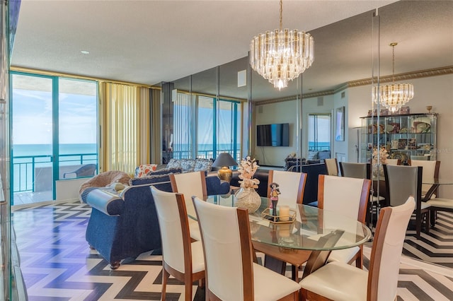 dining room featuring expansive windows, a water view, a chandelier, and a textured ceiling