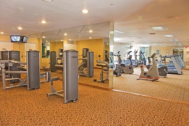 workout area with a textured ceiling and light carpet