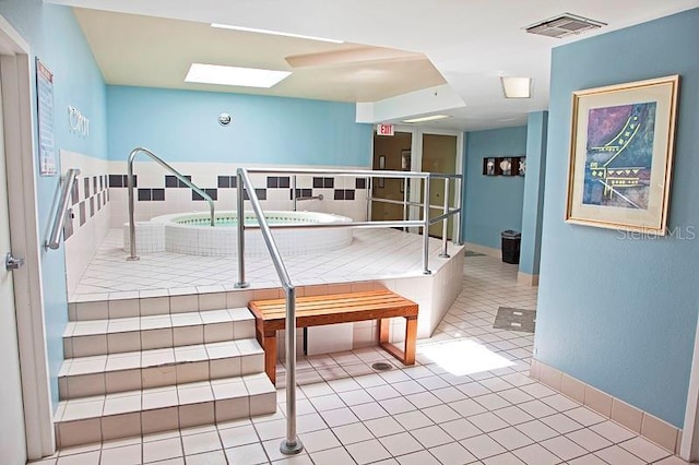 interior space with tile patterned floors and a skylight