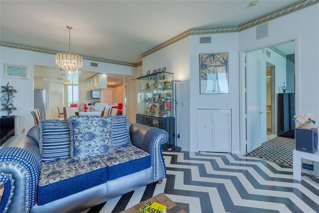 living room with a chandelier, a textured ceiling, and crown molding