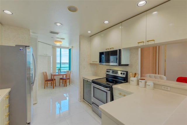 kitchen with kitchen peninsula, light tile patterned floors, and appliances with stainless steel finishes