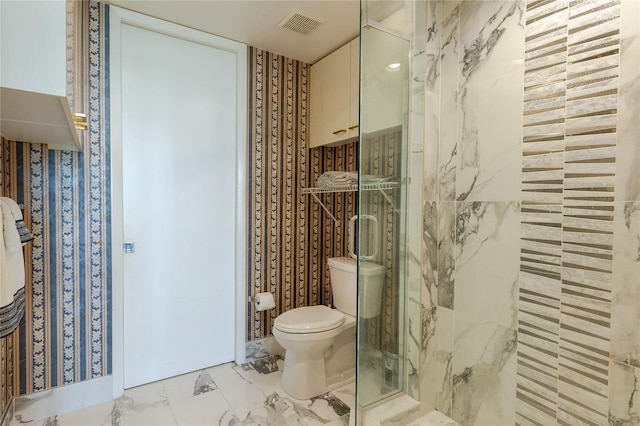 bathroom with a shower with shower door and toilet