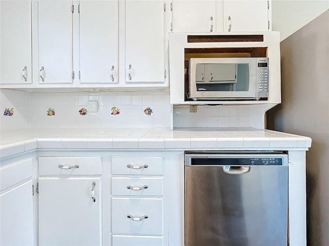 kitchen with backsplash, tile countertops, white cabinets, and stainless steel appliances