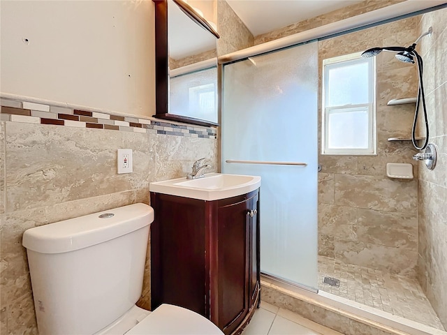 bathroom with a shower with door, vanity, tile walls, and toilet