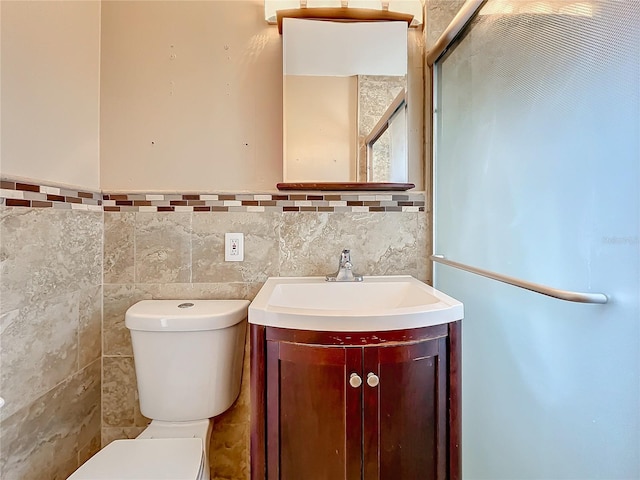 bathroom with vanity, tile walls, and toilet