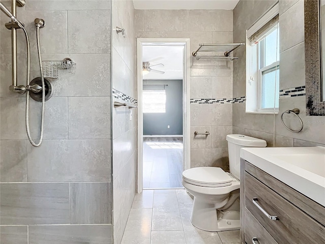 bathroom featuring vanity, ceiling fan, tile walls, tile patterned flooring, and toilet