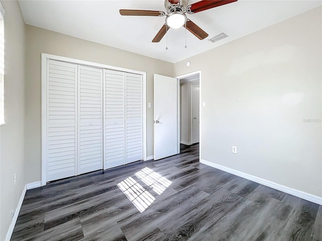 unfurnished bedroom featuring dark wood-style floors, visible vents, and baseboards