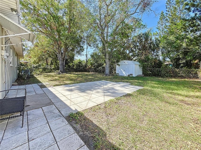 view of yard featuring an outbuilding, a shed, and a patio area