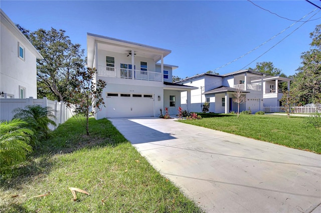 view of front of home with ceiling fan, a balcony, a front yard, and a garage