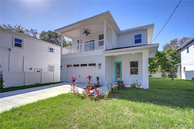 view of front of house with ceiling fan, a front yard, and a garage