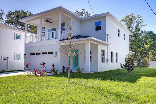 view of front of house featuring ceiling fan, a garage, and a front yard