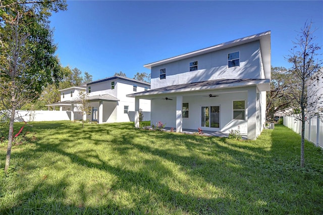 back of property featuring a yard and ceiling fan