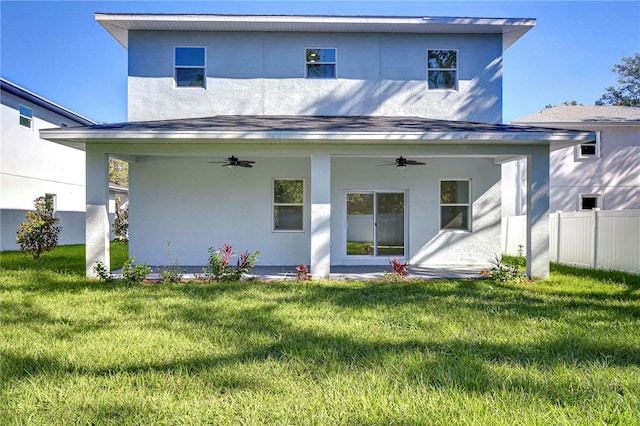 rear view of house with a lawn and ceiling fan