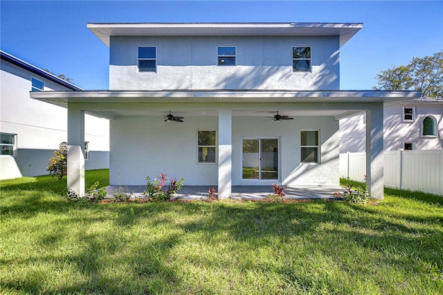 rear view of house with a lawn and ceiling fan