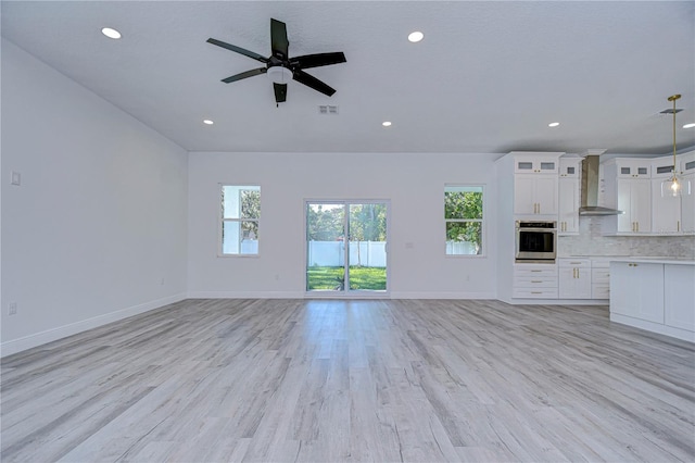 unfurnished living room with ceiling fan and light wood-type flooring