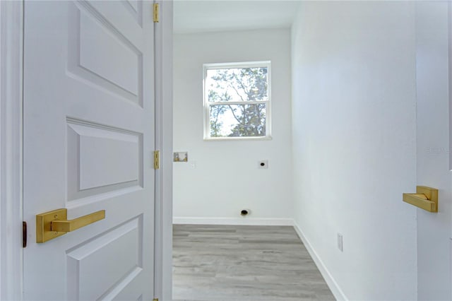 clothes washing area with light wood-type flooring and hookup for an electric dryer