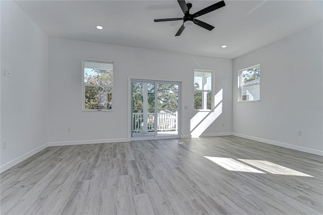 spare room with light wood-type flooring, plenty of natural light, and ceiling fan