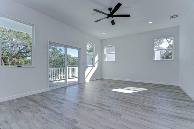 empty room with ceiling fan and light hardwood / wood-style floors