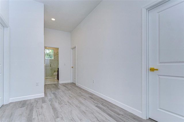 spare room with light hardwood / wood-style floors and vaulted ceiling