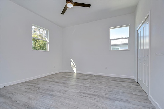 empty room with light wood-type flooring, ceiling fan, and a healthy amount of sunlight