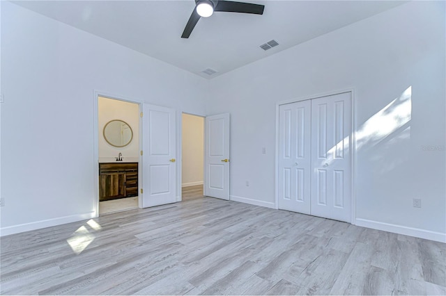 unfurnished bedroom with ceiling fan, a closet, sink, and light wood-type flooring