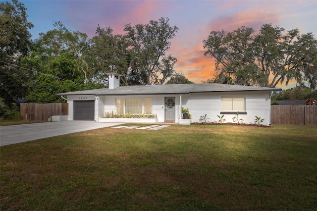 ranch-style home with a garage and a yard