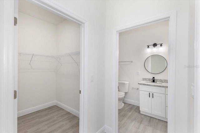 bathroom featuring toilet, vanity, and hardwood / wood-style flooring