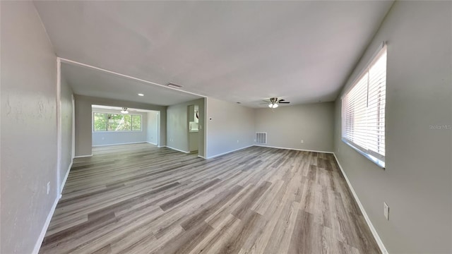 unfurnished living room featuring ceiling fan and light hardwood / wood-style flooring