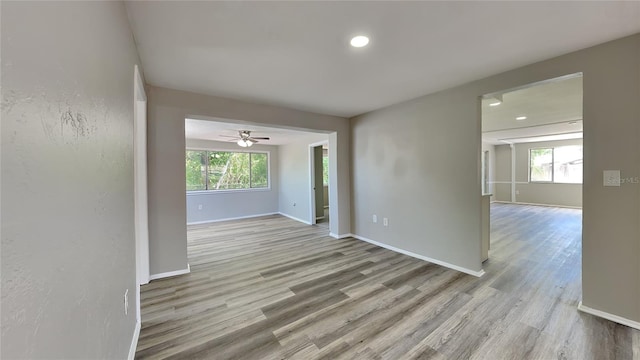 spare room with ceiling fan, plenty of natural light, and light wood-type flooring