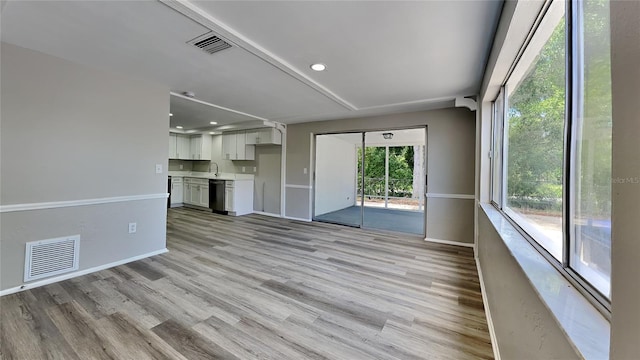 unfurnished living room featuring light wood-type flooring and sink