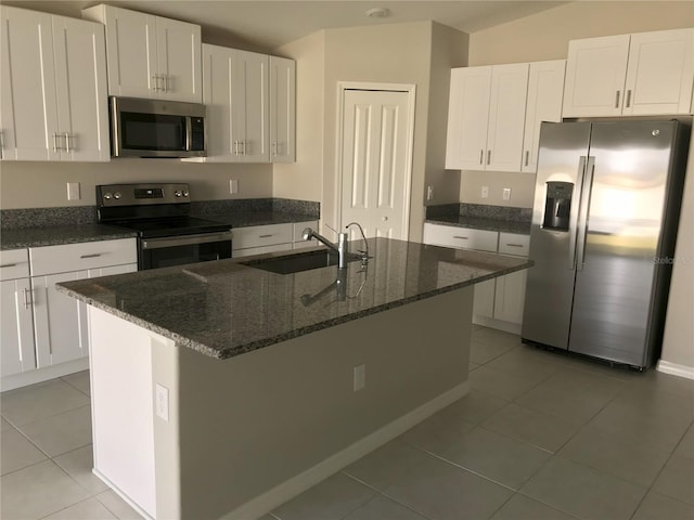 kitchen featuring white cabinets, tile patterned floors, sink, an island with sink, and stainless steel appliances