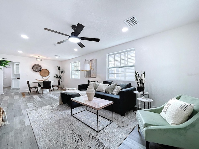 living room featuring light hardwood / wood-style floors and ceiling fan