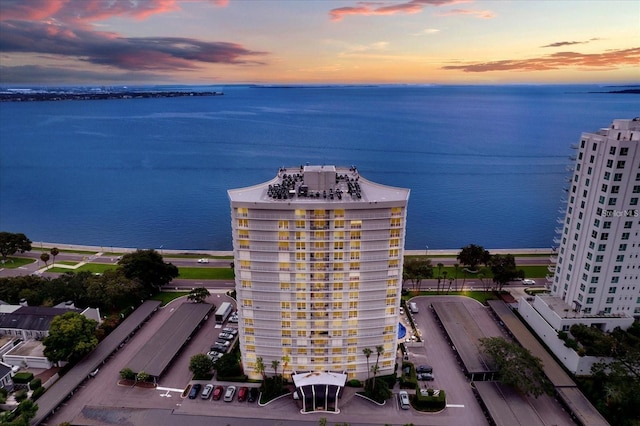 aerial view at dusk featuring a water view