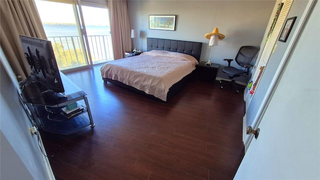 bedroom featuring access to exterior and dark hardwood / wood-style flooring