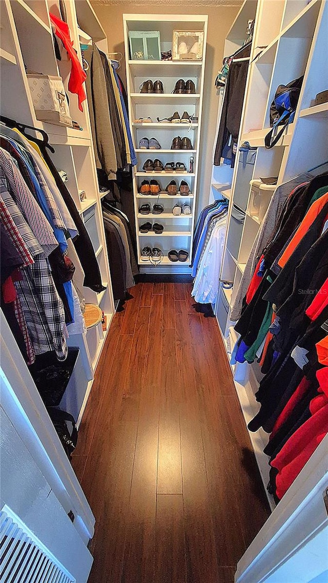 walk in closet with dark wood-type flooring