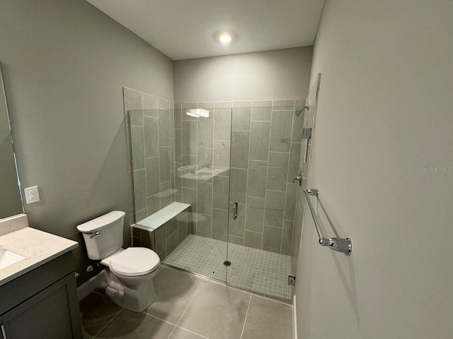 bathroom featuring toilet, vanity, tile patterned floors, and walk in shower