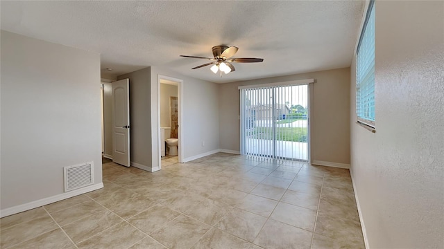 tiled empty room featuring a textured ceiling and ceiling fan