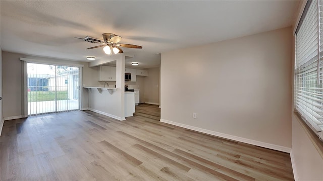 unfurnished living room with ceiling fan and light hardwood / wood-style floors