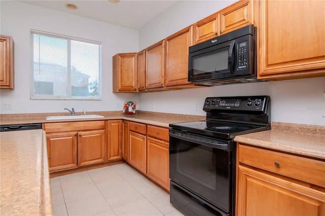 kitchen featuring light tile patterned flooring, sink, and black appliances