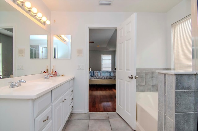 bathroom featuring tile patterned floors, vanity, and a bathing tub