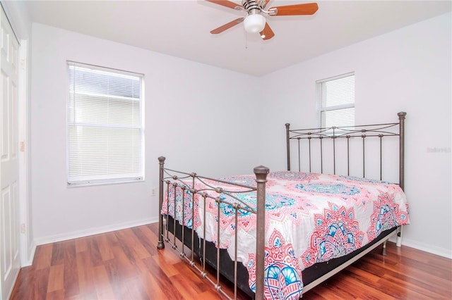 bedroom with multiple windows, ceiling fan, and hardwood / wood-style flooring