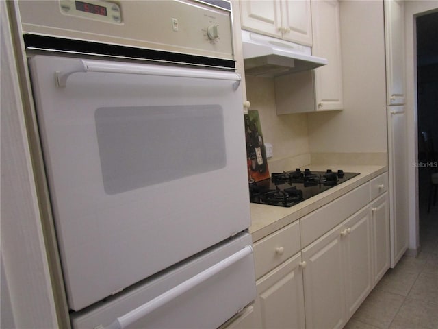 6000 20th St N Unit 114, Saint Petersburg, FL 33714 - kitchen featuring black gas cooktop, under cabinet range hood, light countertops, and white cabinets