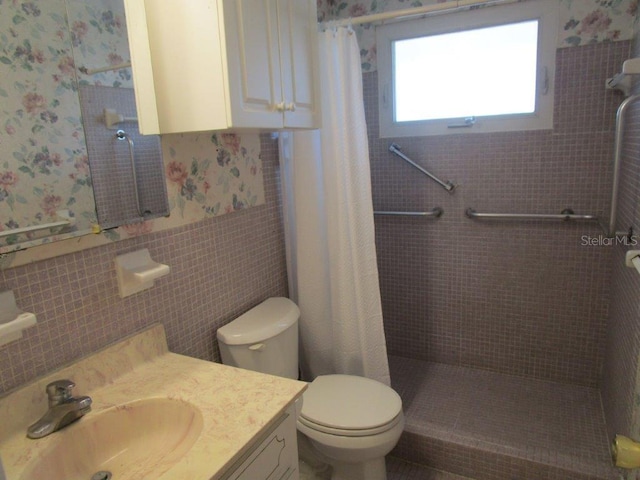 6000 20th St N Unit 114, Saint Petersburg, FL 33714 - full bath featuring a tile shower, wallpapered walls, wainscoting, toilet, and vanity