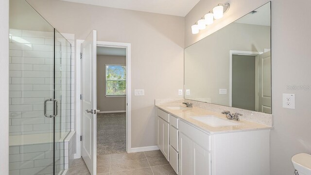 bathroom featuring tile patterned floors, a shower with shower door, and vanity