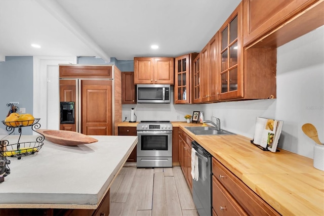 kitchen featuring stainless steel appliances, light hardwood / wood-style floors, and sink