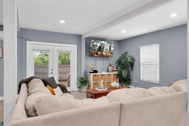 living room featuring beamed ceiling and french doors